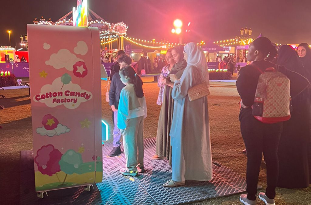 A family waits for the cotton candy machine to finish making the cotton candy